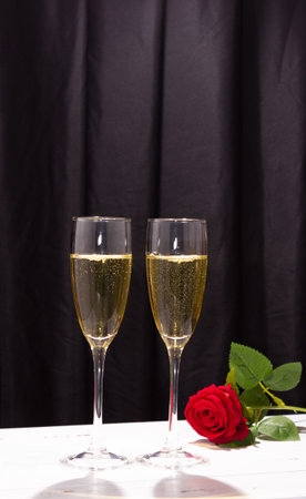 Champagne glasses on a dark background and a red rose. The concept of Valentine's day.の写真素材