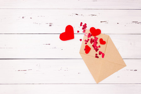 Red hearts and an open letter envelope made of kraft paper