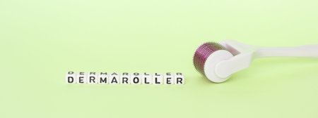 White roller with mesotherapy handle and the inscription dermaroller. The concept of cosmetic...
