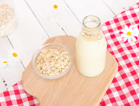 Glass bottle with vegetable oat milk and oat flakes. Lactose-free milk, vegetarianism.の写真素材