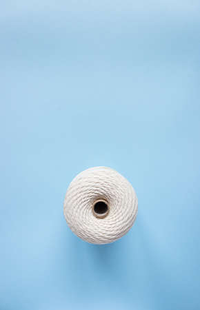 A skein of white cotton cord on a blue background, free space.の写真素材