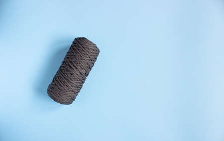 A skein of black polyester cord and polyester cord on a blue background, free space.の写真素材