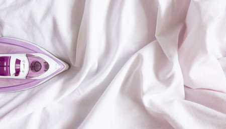 A piece of iron on a white crumpled cloth. Homework, ironing.の写真素材