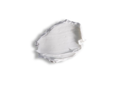 Swatch texture of white cream with shadow isolated on a white background.