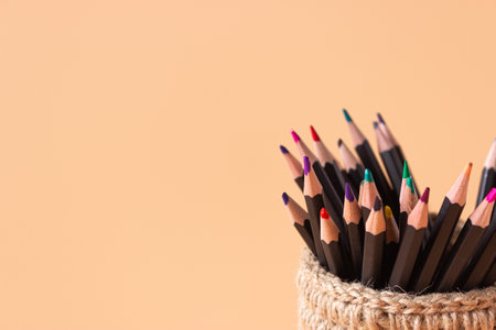 Colored pencils in a wicker basket made of jute on a beige background. Executive Officeの写真素材