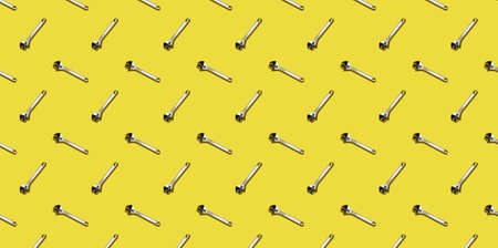 Adjustable keys on a yellow background, pattern, hard shadows. Construction tools, repairs. Background for the design.の写真素材