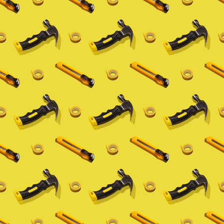 Hammers, knives, and duct tape on a yellow background, pattern, hard shadows. Construction tools, repairs. Background for the design.の写真素材