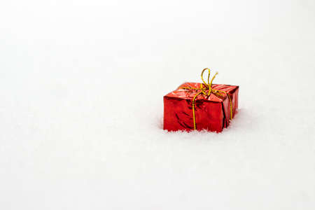 Red christmas gift on white snow backgroundの写真素材
