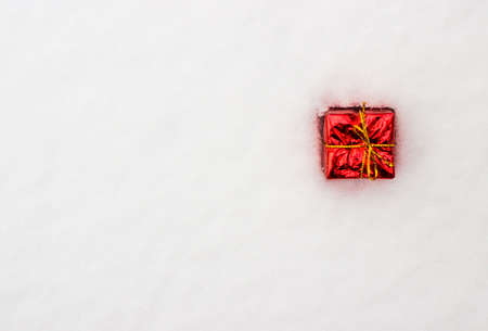 Christmas decoration, red gift box in snow, flat lay, copyspaceの写真素材