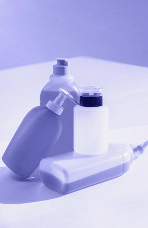 Bottles with liquid soap, shampoo and acetone on white background. Toned in very peri color of the year 2022の写真素材