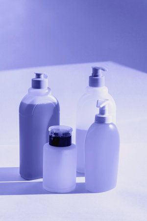 Bottles with liquid soap, shampoo and acetone on white background. Toned in very peri color of the year 2022の写真素材