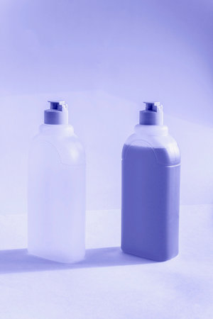 Bottles with liquid soap, shampoo and acetone on white background. Toned in very peri color of the year 2022の写真素材