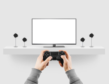 Man hold gamepad in hands in front of blank tv screen mock up playing game. Clear monitor mockup...