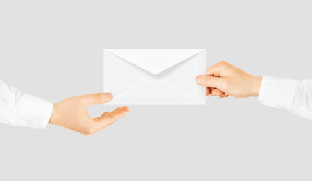 White blank envelope giving hand. Message send presentation. Person taking clear envelope email mockup. Post shipping delivering. Sharing mail message. Sending message men.の写真素材