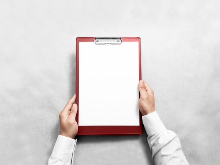 Hand holding blank red clipboard with white paper design mockup.