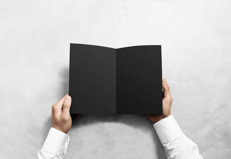 Hand opening blank black brochure booklet mockup. Leaflet presentation. Pamphlet mock up holding hand. Man show clear offset paper. Booklet design template. A5 paper sheet display read first personの写真素材