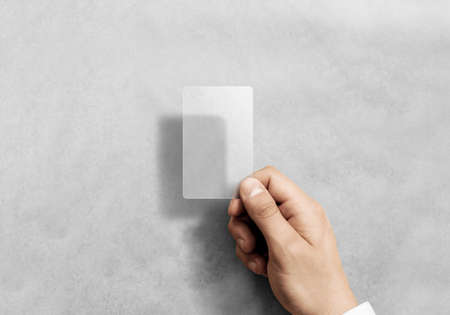 Hand hold blank vertical translucent card mockup with rounded corners. Plain clear call-card mock up template holding arm. Plastic transparent acrylic namecard display front.の写真素材