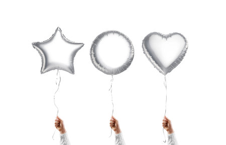 Hand holding blank silver star, round and heart balloon mockupの写真素材