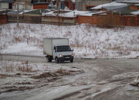 Kazakhstan, Ust-Kamenogorsk, February 16, 2019: Car on the road on the outskirts of the city. Grunge cityscape. Darkのeditorial素材