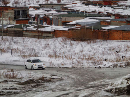 Kazakhstan, Ust-Kamenogorsk, February 16, 2019: Car on the road on the outskirts of the city. Grunge cityscape. Darkのeditorial素材