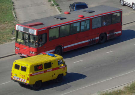 Kazakhstan, Ust-Kamenogorsk, August 11, 2019: Bus and ambulance car. Public transport and ambulance. Traffic. Cityscapeのeditorial素材