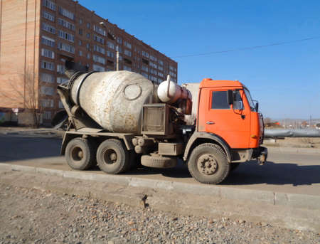 Concrete mixer on the street. Construction engineering. Orange truck. Blue sky. Ust-Kamenogorsk (Kazakhstan)のeditorial素材