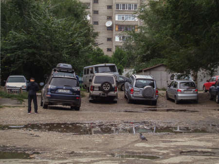 Kazakhstan, Ust-Kamenogorsk, September 11, 2019: Cars parked near the apartment building. Vehicles. Old residential areaのeditorial素材