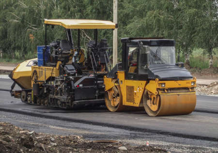 Paver and steamroller. Road repair. Drum roller and asphalt spreading machine. Ust-Kamenogorsk (Kazakhstan)のeditorial素材