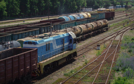 Switcher or shunter moves along the railway tracks in Ust-Kamenogorsk (Kazakhstan). Freight wagons...