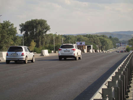 Kazakhstan, Ust-Kamenogorsk, august 16, 2019: Traffic on one of the streets of the city. Bridgeのeditorial素材