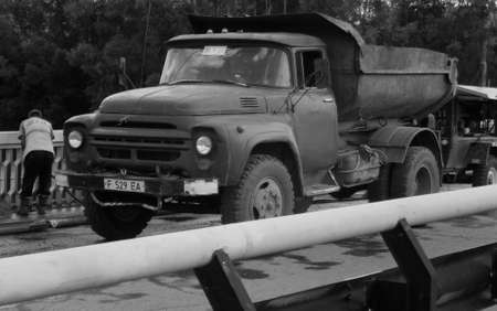 Kazakhstan, Ust-Kamenogorsk, august 25, 2018: Old dump truck ZIL 130. Road reconstruction works. Workerのeditorial素材