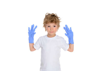 A small white boy is standing on a white isolated background and showing number two with his fingers while smiling broadly and his hair is tousled.の写真素材