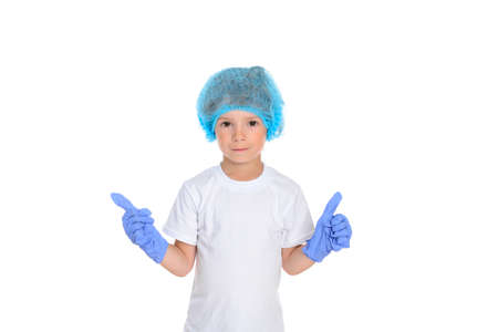 A small white boy is standing on a white isolated background and showing number two with his fingers while smiling broadly and his hair is tousled.の写真素材