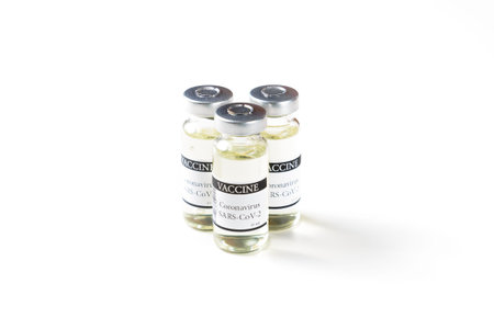 COVID-19 coronavirus vaccine concept - glass ampoules with metal caps on white isolated background....
