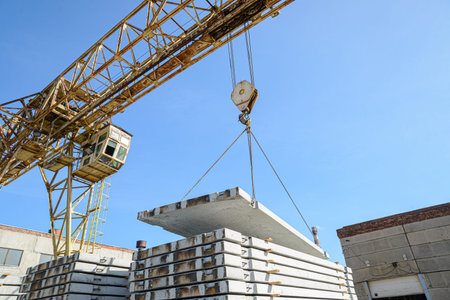 The gantry crane moves the reinforced concrete road slab. Factory warehouse.の写真素材