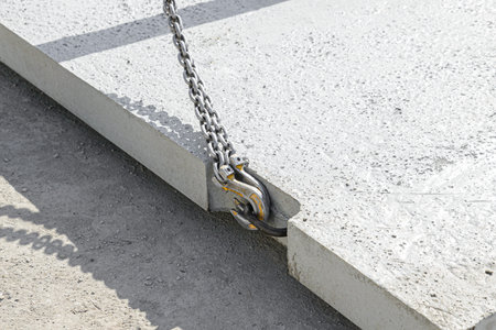 Close-up of slings with hooks hooked into the loop of a reinforced concrete slabの写真素材