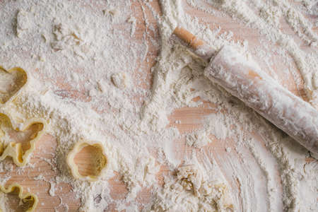 Close-up wooden rolling pin lying on the kitchen table with flourの写真素材