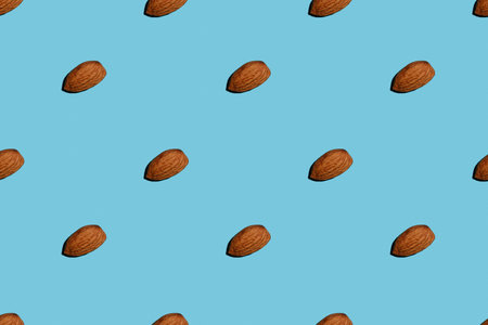 Almond nut on blue isolated background, pattern, mock up close upの写真素材