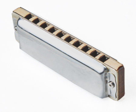 silver diatonic blues harmonica on white background