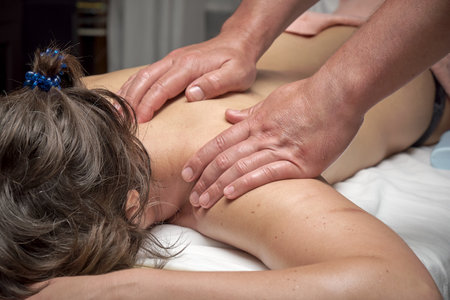 woman takes a massage course, hands of masseur close upの写真素材