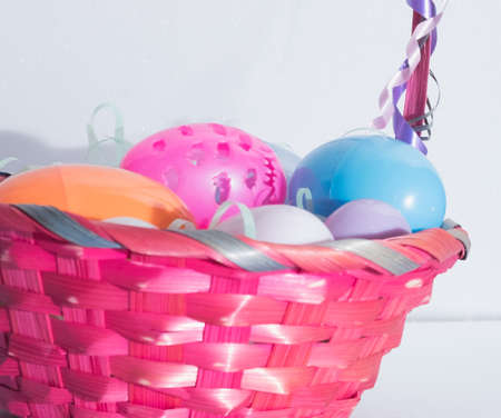 colored easter eggs in a wicker basketの写真素材