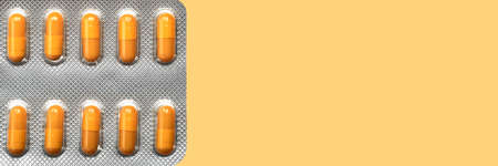 blister with mustard color capsules on light yellow background, ad banner conceptの写真素材