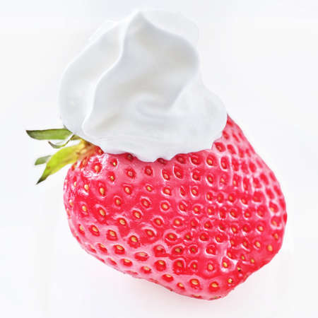 ripe juicy strawberries covered with a hat of whipped cream, close-upの写真素材