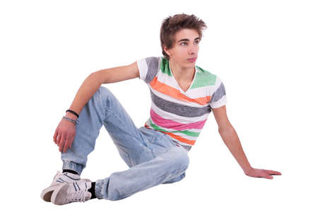 young man sitting, isolated on white, studio shotの写真素材