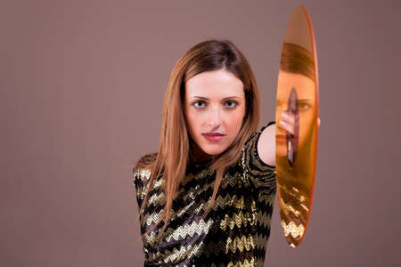 beautiful blonde woman standing holding a golden vinyl disc,  studio shotの写真素材