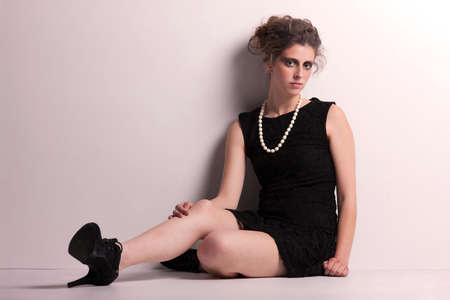 Beautiful young woman on the floor, studio shotの写真素材