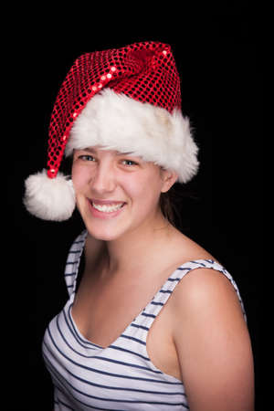 Beautiful christmas girl smiling, on black background, studio shotの写真素材