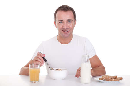 handsome man taking breakfast, isolated on white, studio shotの写真素材