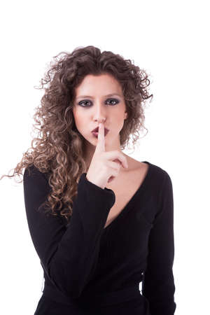 Beautiful young woman asking for silence, with curly hair, isolated on white background. Studio shot.の写真素材
