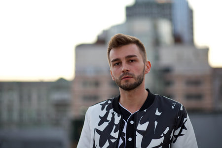 A handsome man in a white and black suit and a sad, languid look. A guy with stubble and a model hairstyle in a fashionable suit and a seductive look.の写真素材